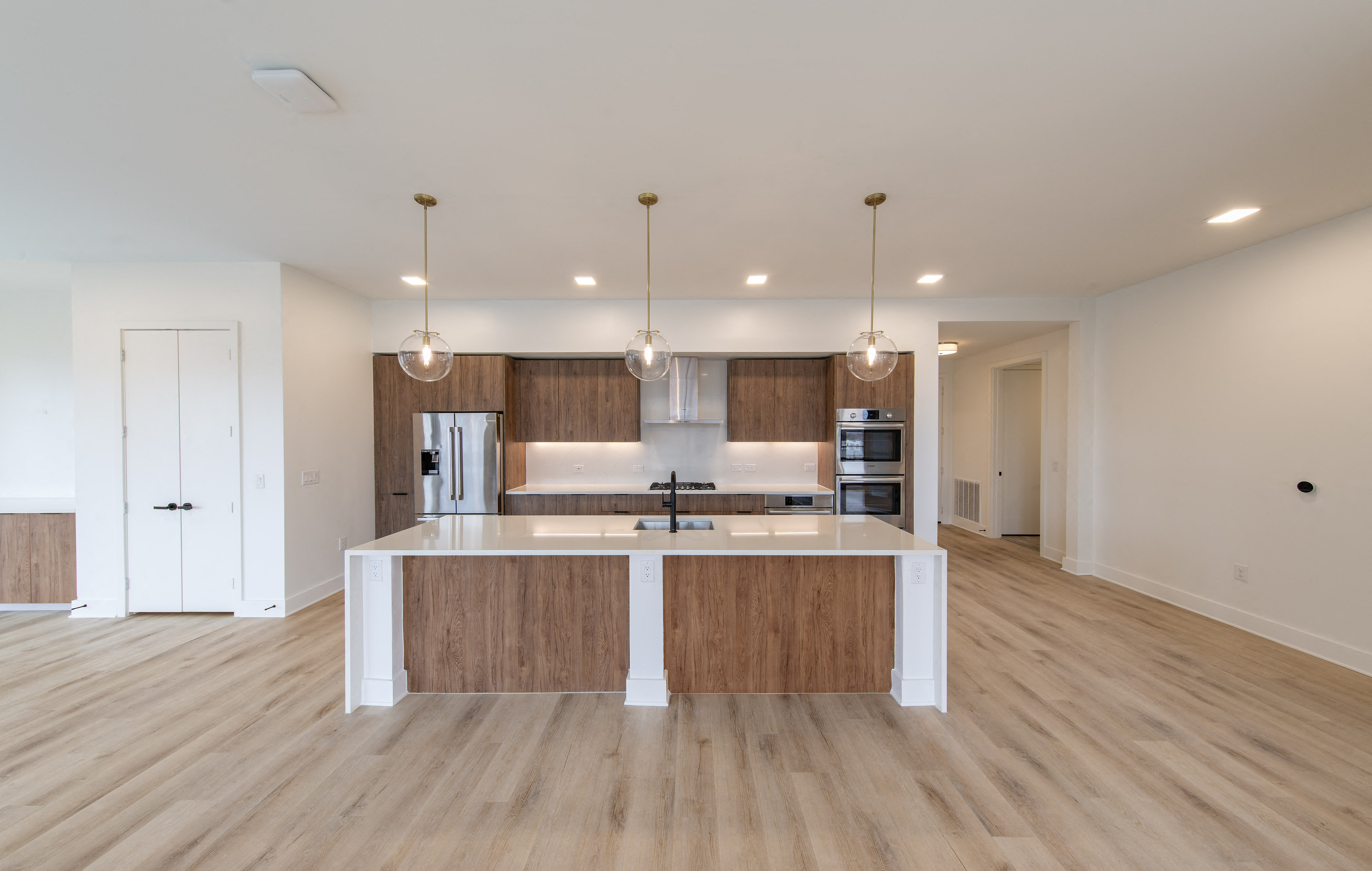 a kitchen and living room with a large island and wood flooring