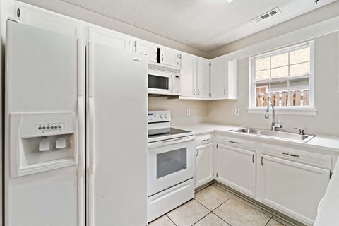a kitchen with white appliances and white cabinets