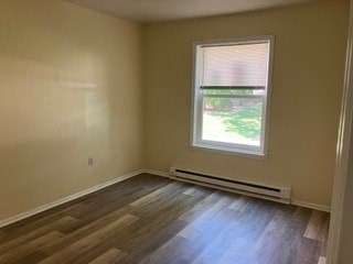 A room with a window and a wooden floor.