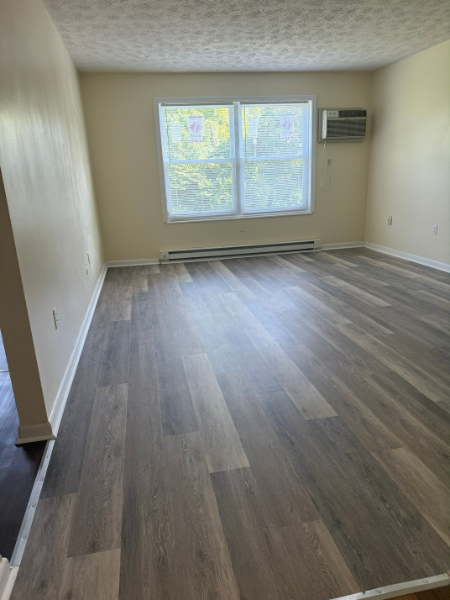 A room with wooden flooring and a window.