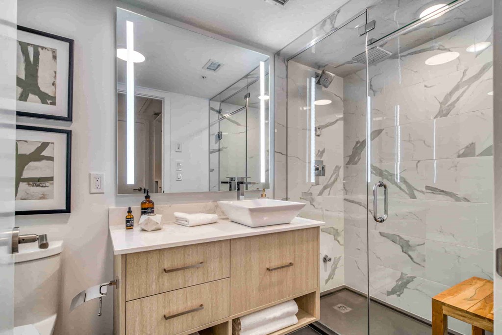 a bathroom with a shower and a vanity with two sinks