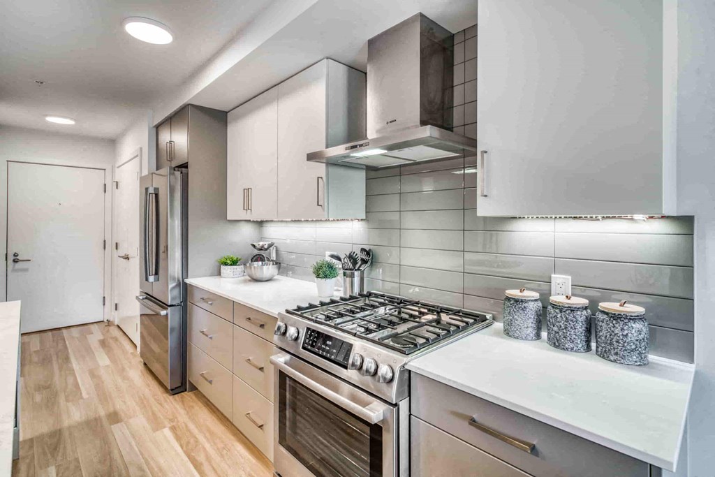 a white kitchen with a stove and a refrigerator