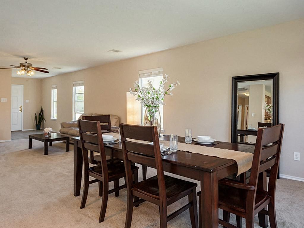 a dining room with a wooden table and chairs