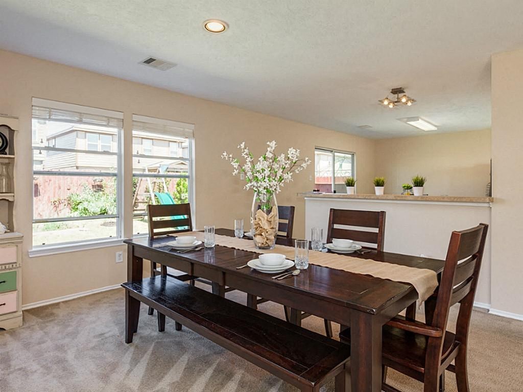 a dining room with a wooden table and chairs