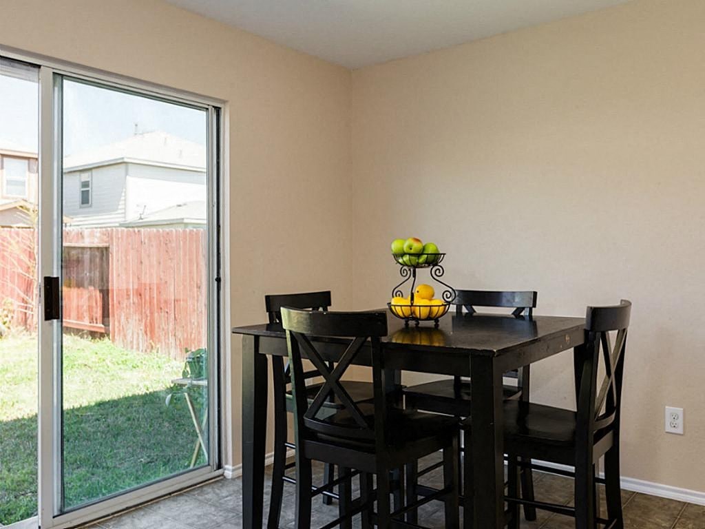 a dining room with a table and chairs and a sliding glass door