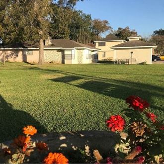 a yard with flowers in front of a house
