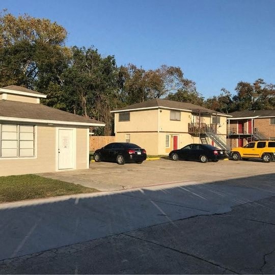 a parking lot with cars parked in front of houses