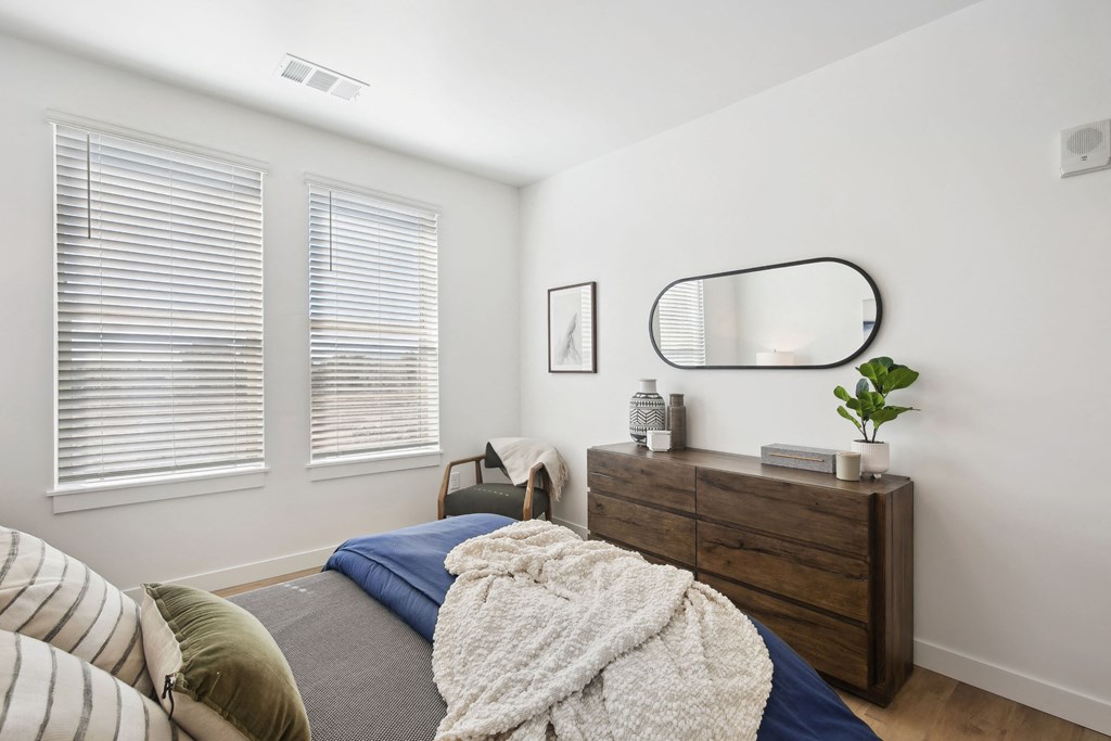 a bedroom with a bed and a dresser with a mirror