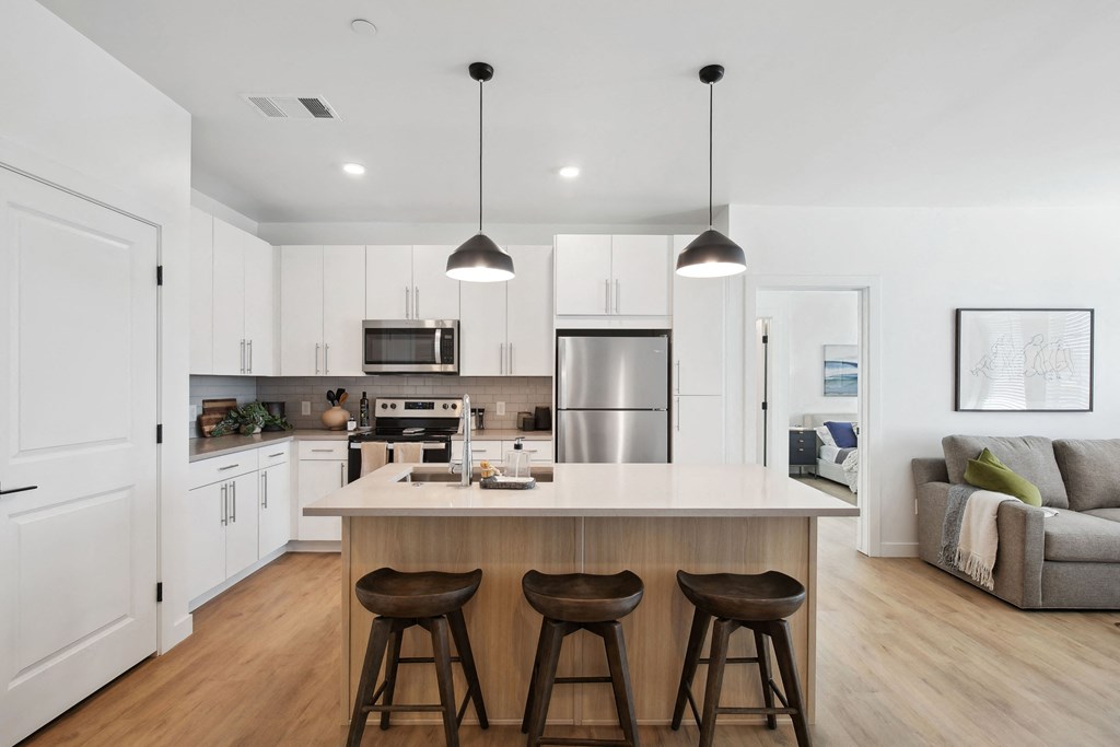 a kitchen with a large island with three stools