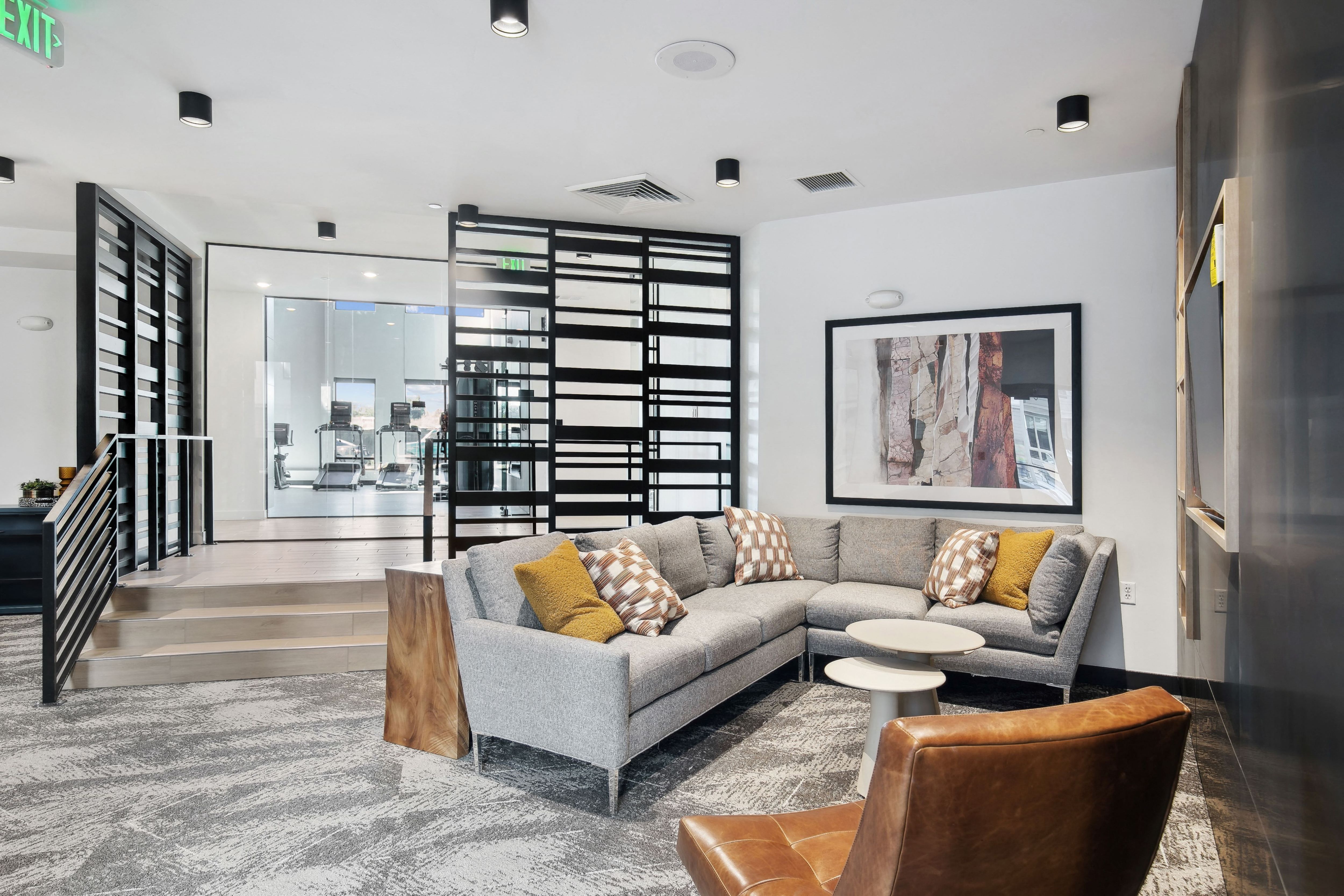 a living room with a couch and chairs and a spiral staircase