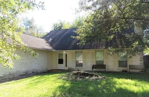 A house with a white wall and a brown roof.