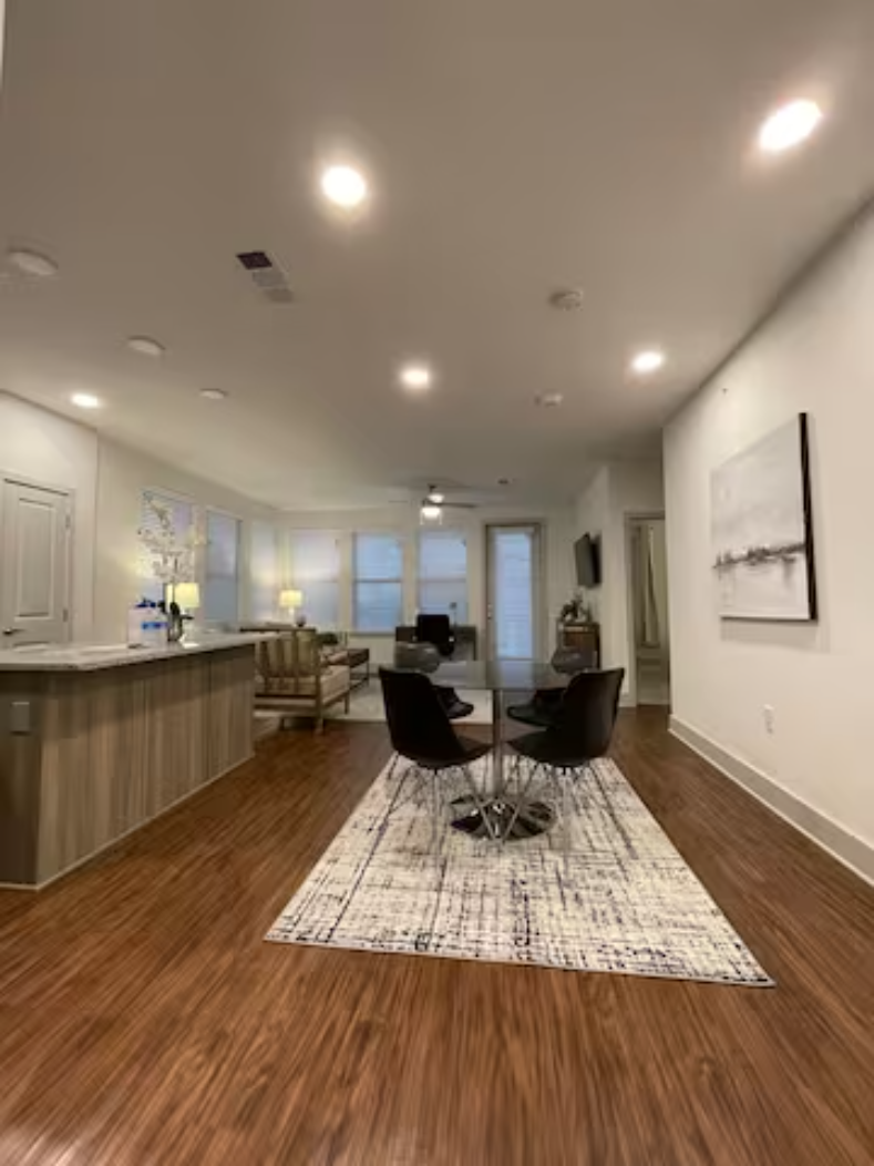 an open living room with a kitchen and a table and chairs