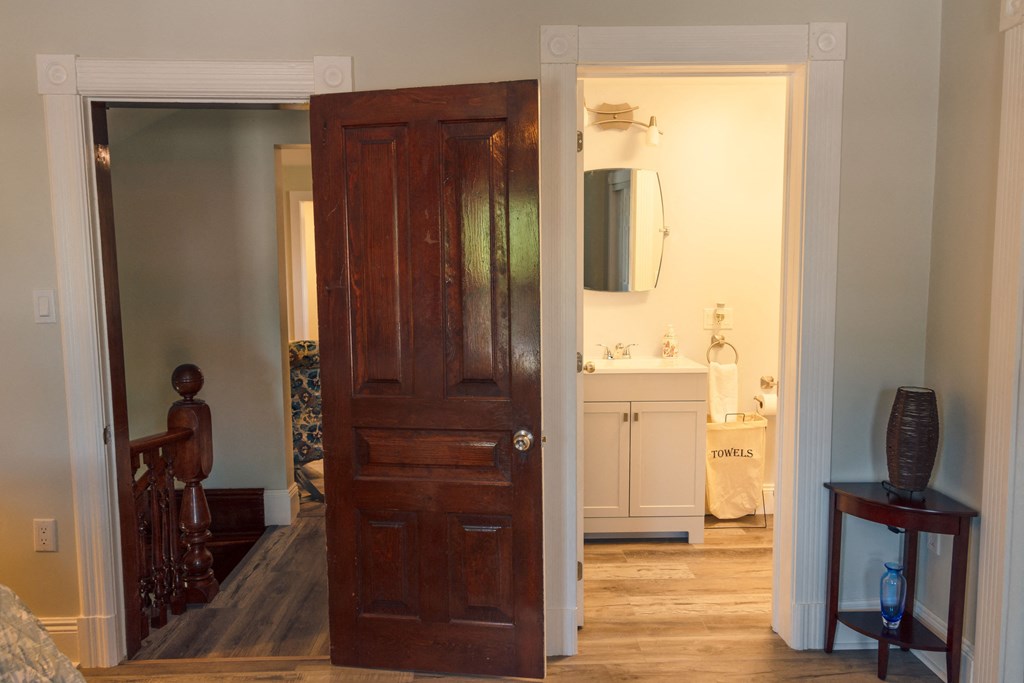 a bedroom door is open to a bathroom with a sink
