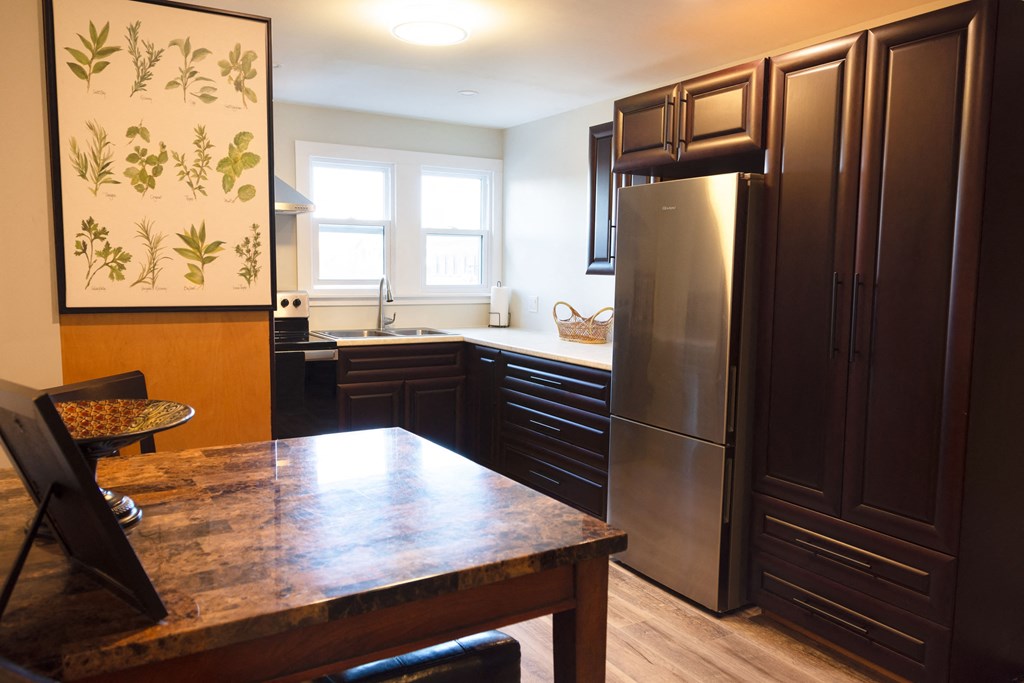 a kitchen with black cabinets and a wooden table