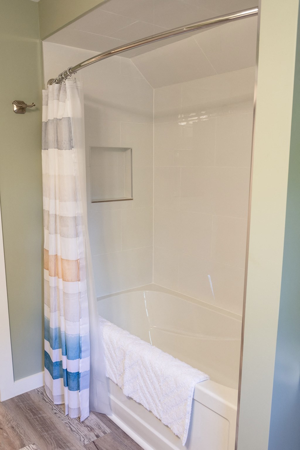 the bathroom has a shower and a tub with a white towel