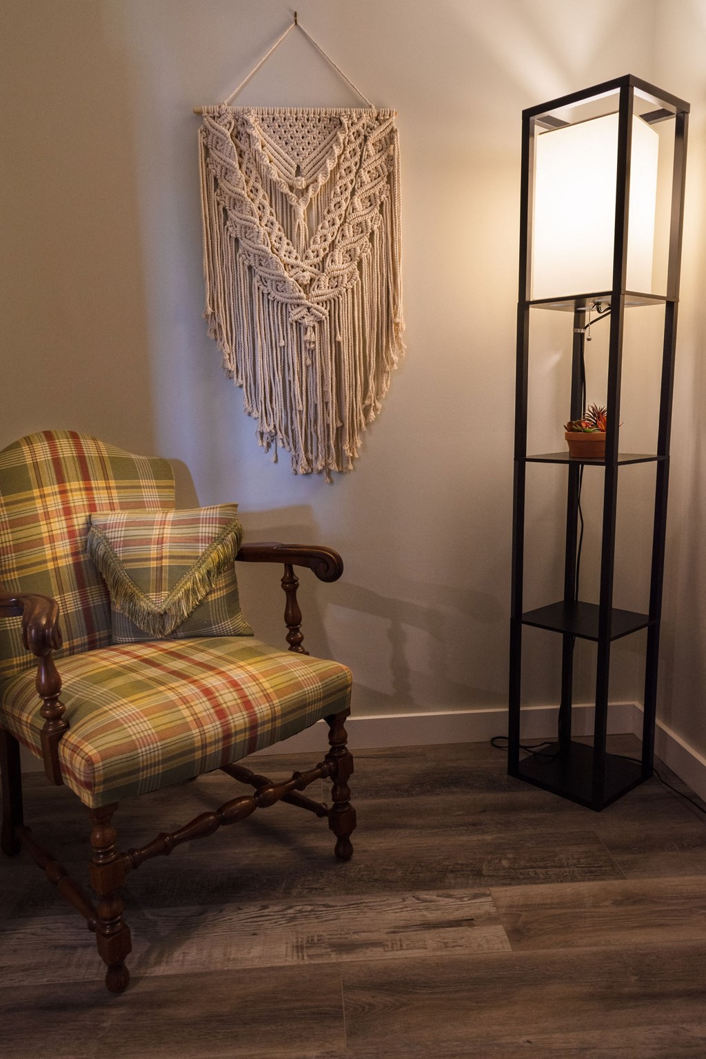 a living room with a chair and a curtain on the wall