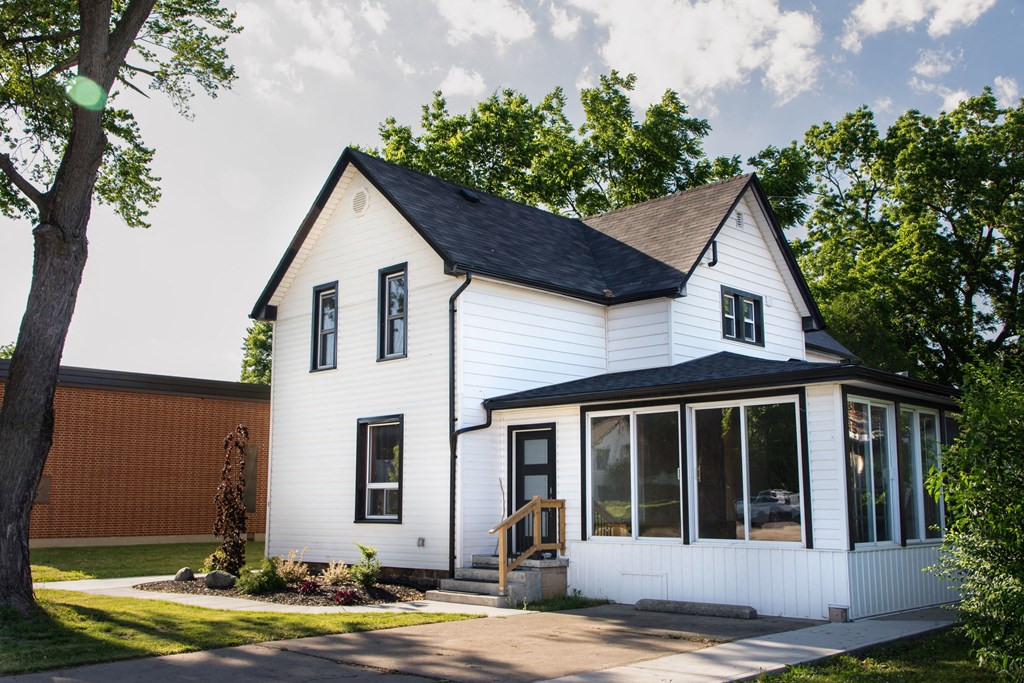 the exterior of a white house with a black roof