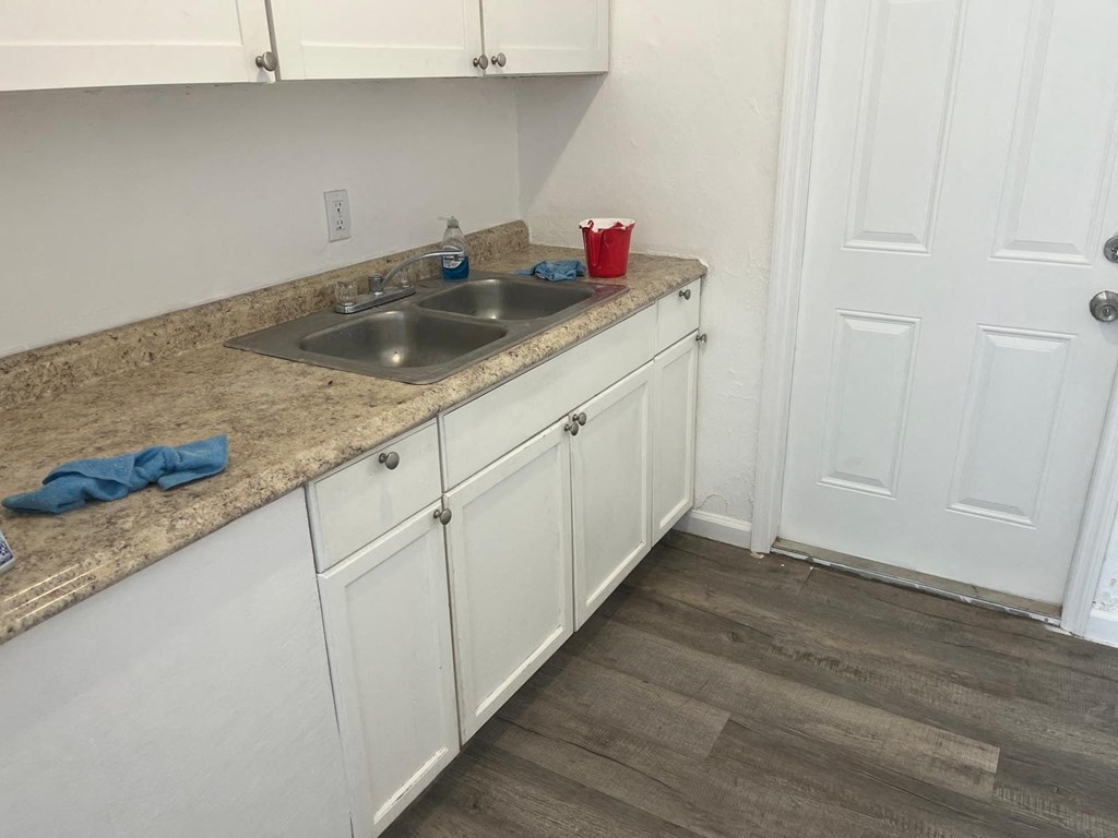 A kitchen with white cabinets and a granite countertop.