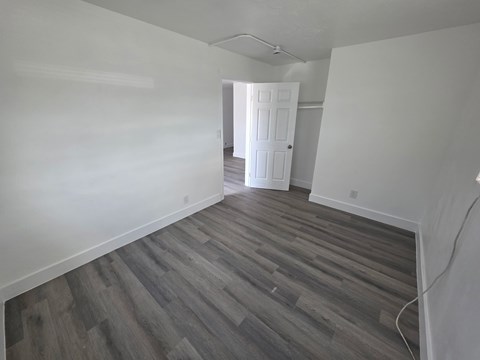 A room with wooden flooring and a white door.