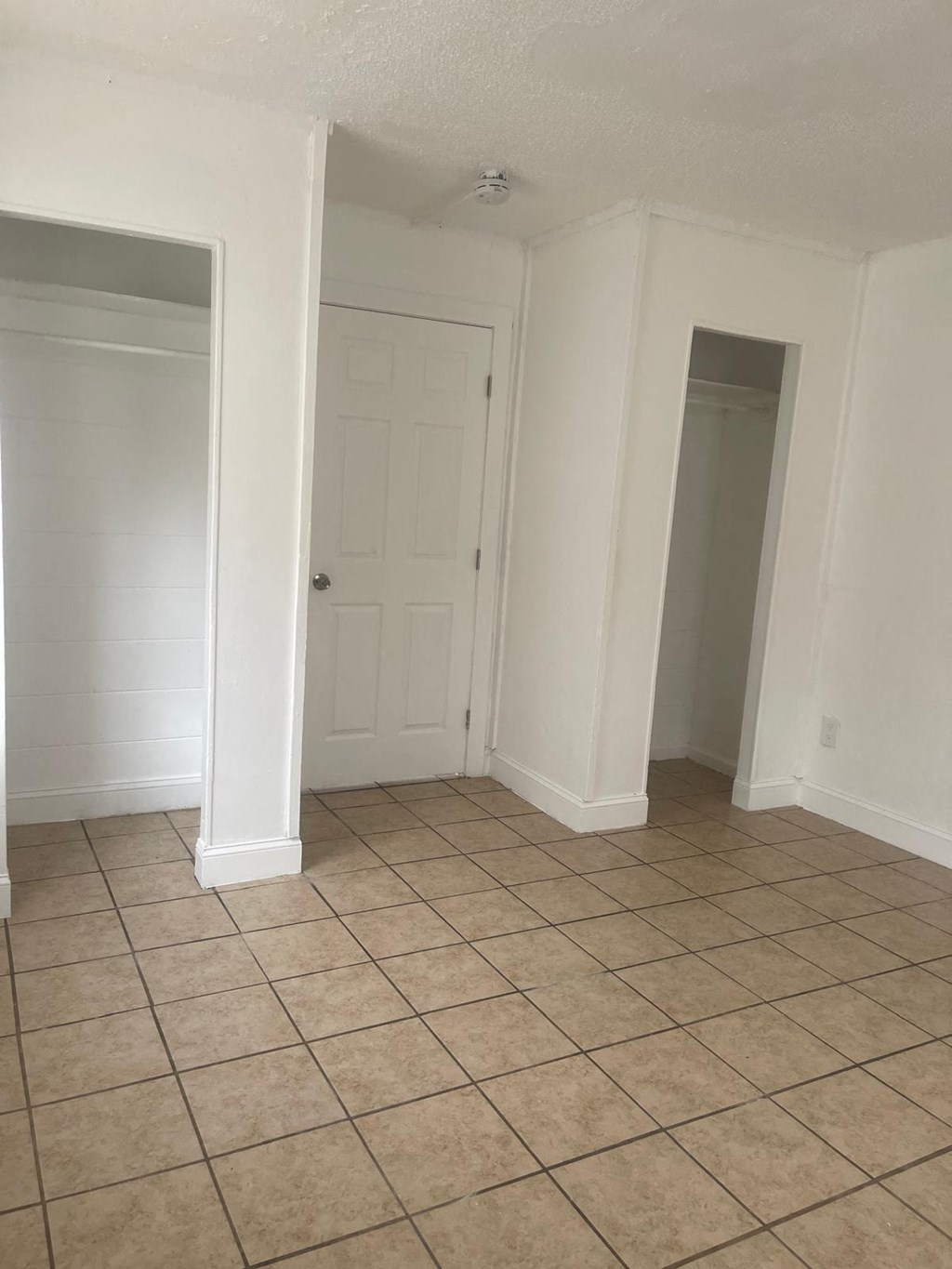 A room with white walls and tile flooring.
