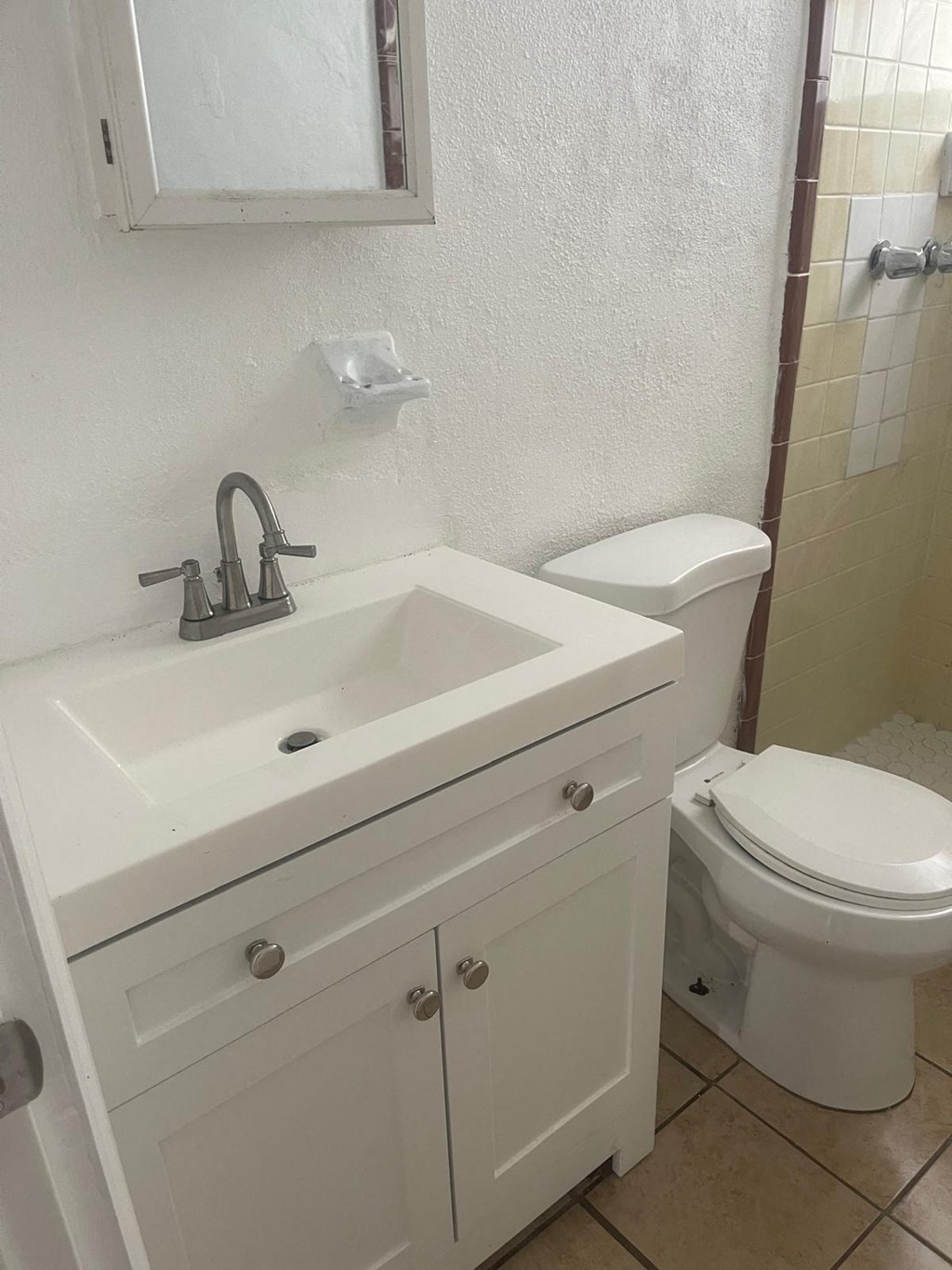 A white bathroom with a toilet and sink.
