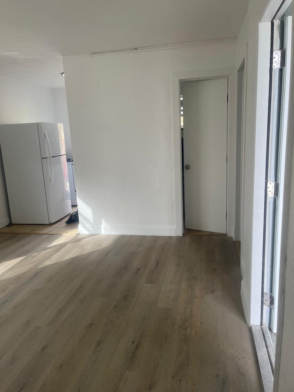 A room with a wooden floor and a white door.