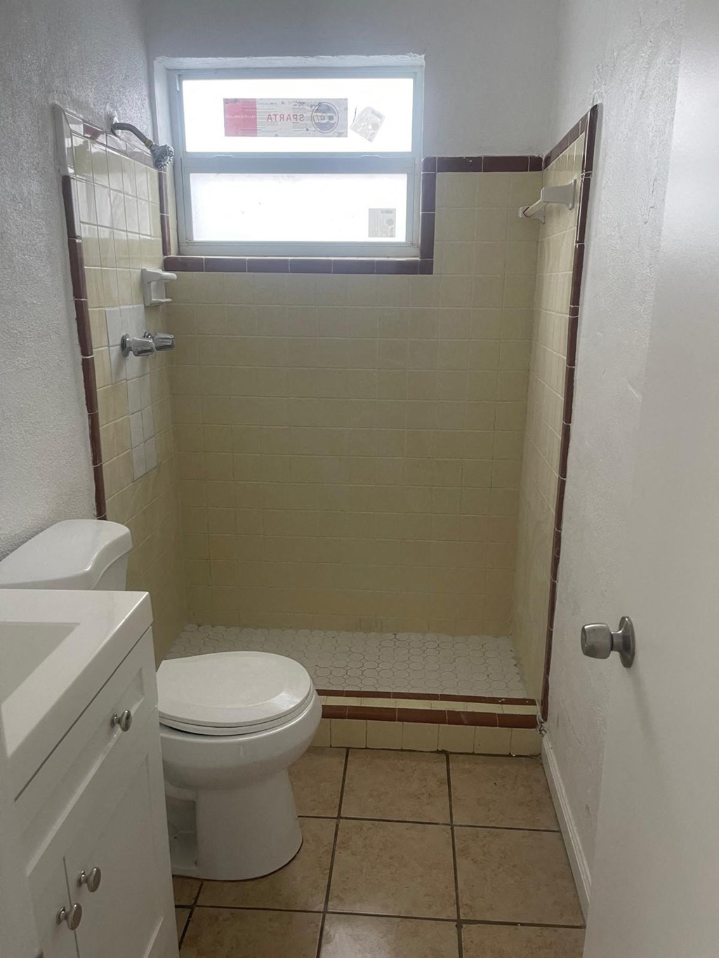 A white toilet sits next to a walk-in shower.