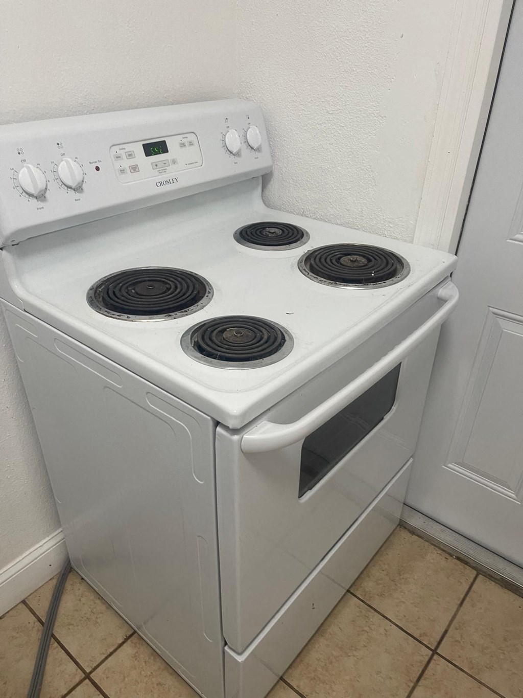 A white oven with four burners and a digital display.