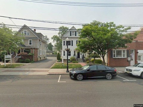 a black car parked in a parking lot on a street