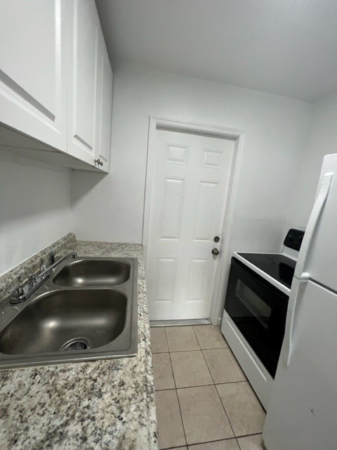 A kitchen with a sink and a refrigerator.