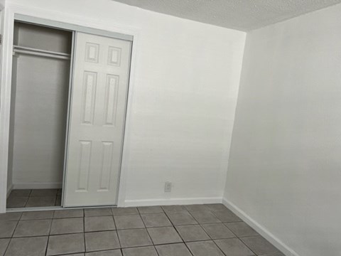 A white door is open in a room with white walls.