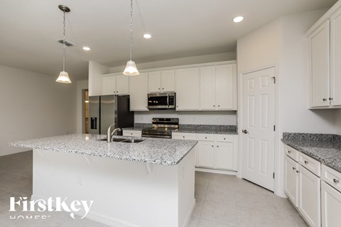 A kitchen with a granite countertop and white cabinets.