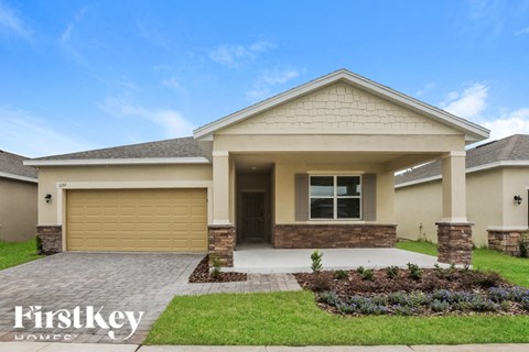 a beige house with a driveway and a garage door