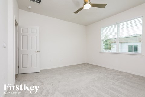a bedroom with a ceiling fan and a window