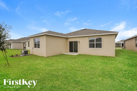 a beige house with a grassy yard in front of it