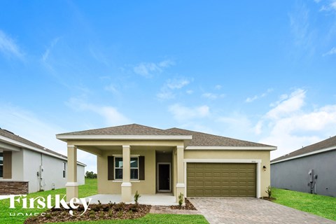 a house with a garage door in front of a green lawn