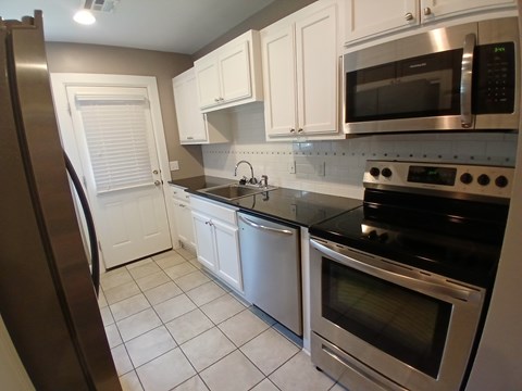 A kitchen with white cabinets and stainless steel appliances.