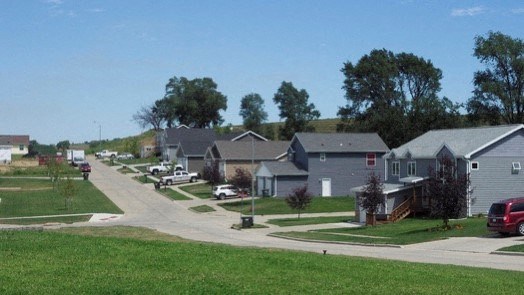 a neighborhood of houses with cars parked in the street