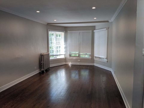 a living room with wood floors and a large window