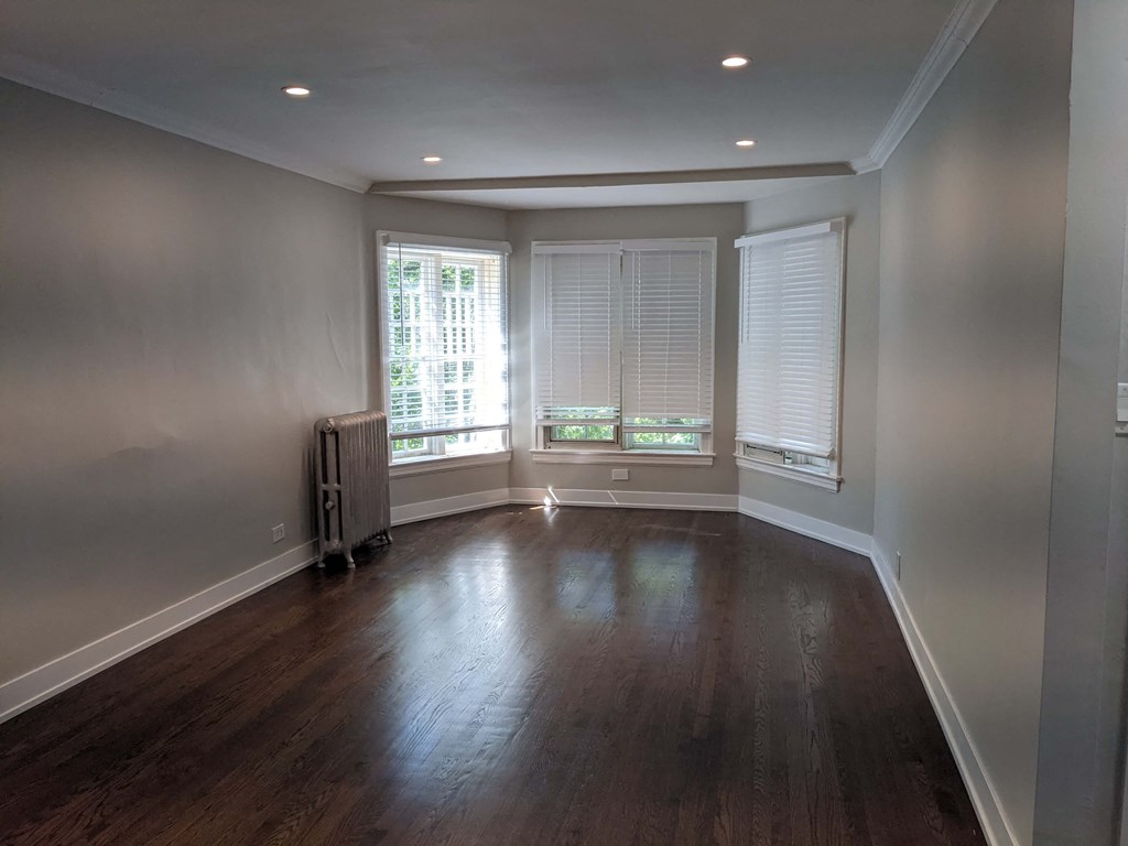 a living room with wood floors and a large window