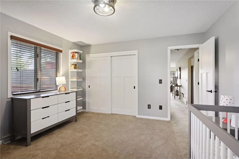 an empty room with a dresser and a window
