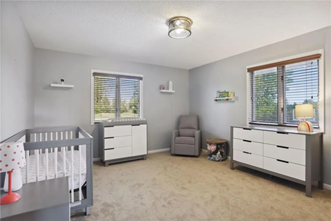 a nursery with a crib and a dresser and a window