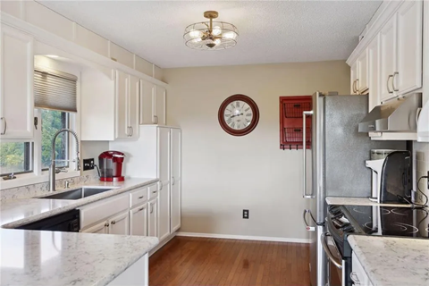 a kitchen with white cabinets and a clock on the wall
