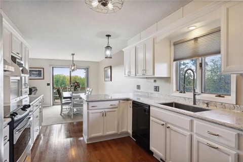 a large kitchen with white cabinets and a black sink