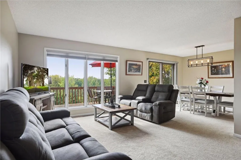 a living room with couches and a table and a balcony