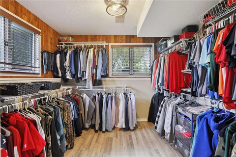 the closet is full of clothes and a rack of clothes