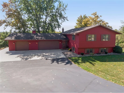a red house with a garage and a driveway