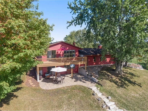 an aerial view of a red house with a deck and a tree