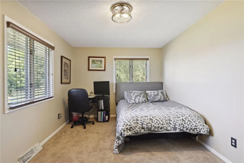 a bedroom with a bed and a desk