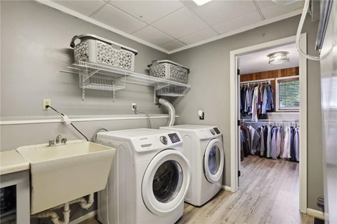 a white washer and dryer in a laundry room with a sink
